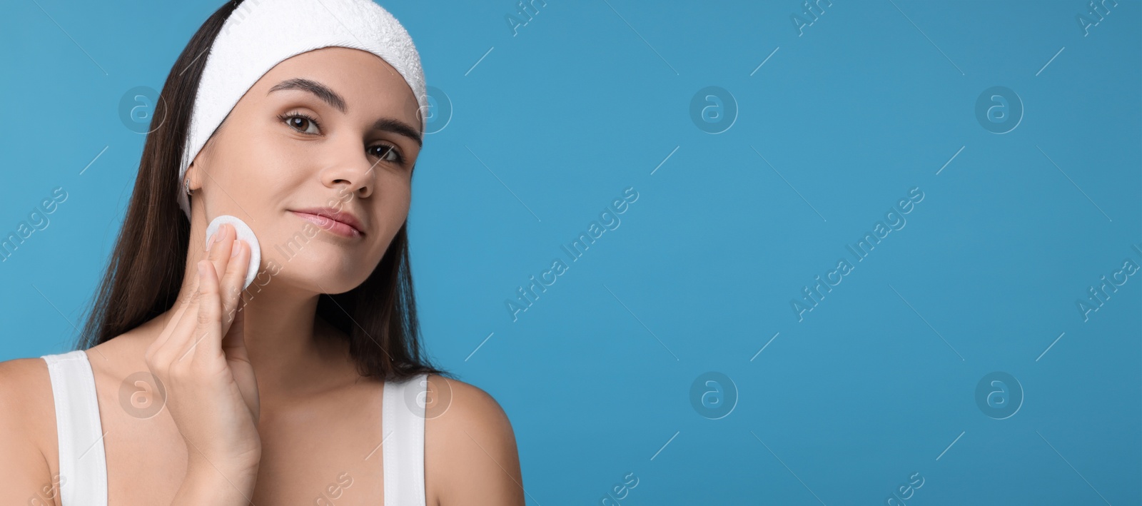 Image of Young woman with cotton pad on light blue background. Banner design with space for text