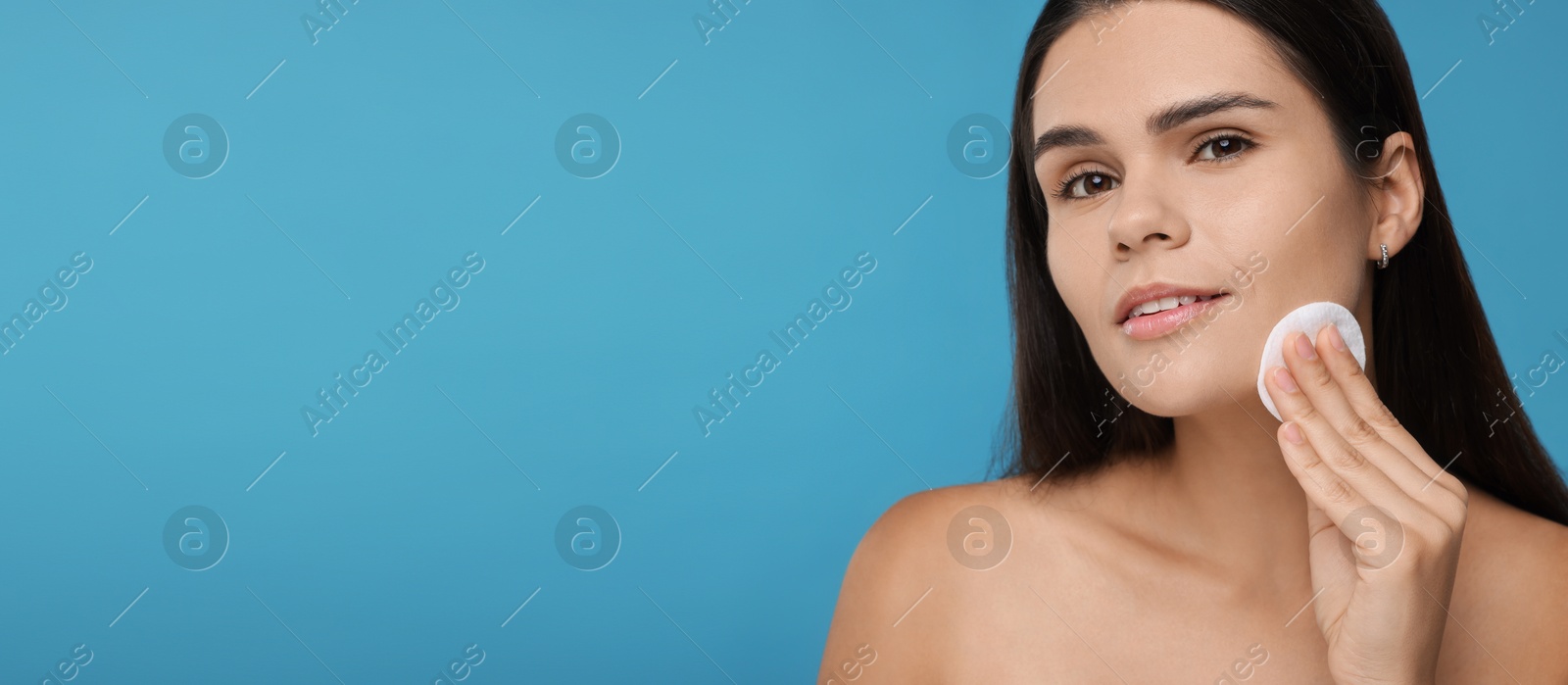 Image of Young woman with cotton pad on light blue background. Banner design with space for text