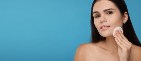 Image of Young woman with cotton pad on light blue background. Banner design with space for text