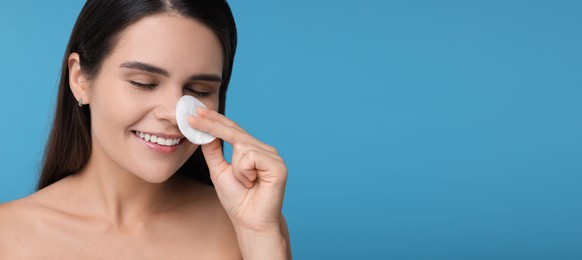 Image of Young woman with cotton pad on light blue background. Banner design with space for text