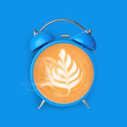 Image of Bright alarm clock with coffee instead of dial on light blue background, top view