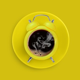 Image of Bright alarm clock with coffee instead of dial on yellow background, top view