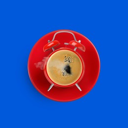 Image of Red alarm clock with coffee instead of dial on blue background, top view