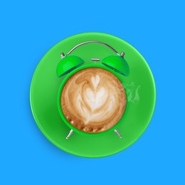 Image of Green alarm clock with coffee instead of dial on light blue background, top view