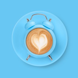 Image of Bright alarm clock with coffee instead of dial on light blue background, top view