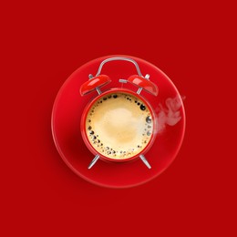 Image of Bright alarm clock with coffee instead of dial on red background, top view