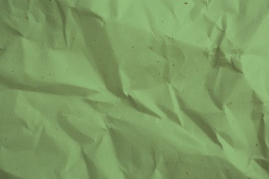 Image of Crumpled sage color parchment paper as background, closeup of texture