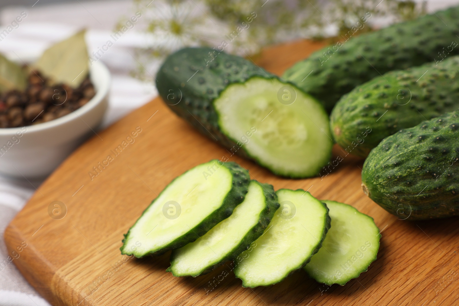 Photo of Fresh whole and cut cucumbers on table, closeup