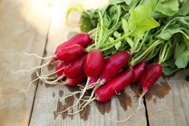 Bunch of freshly harvested radishes on wooden table, closeup