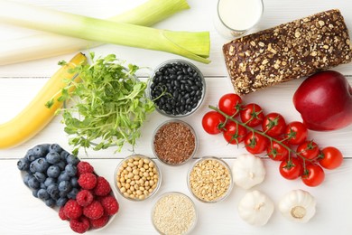 Photo of Different fresh products on white wooden table, flat lay. Source of prebiotics