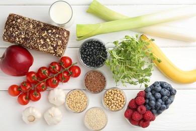 Different fresh products on white wooden table, flat lay. Source of prebiotics