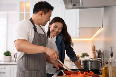 Photo of Happy lovely couple cooking together in kitchen