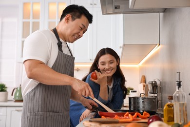 Photo of Happy lovely couple cooking together in kitchen