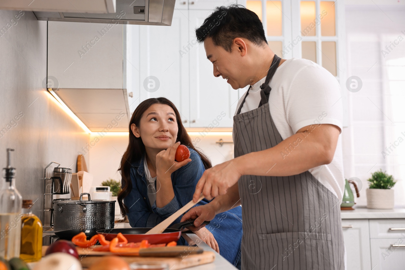 Photo of Happy lovely couple cooking together in kitchen