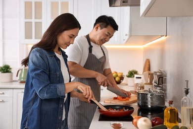 Photo of Happy lovely couple cooking together in kitchen