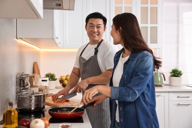 Happy lovely couple cooking together in kitchen