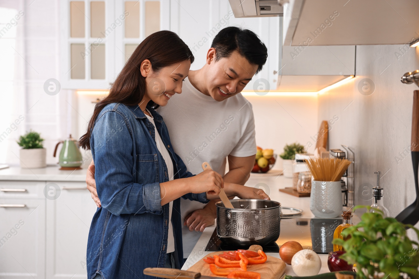 Photo of Happy lovely couple cooking together in kitchen