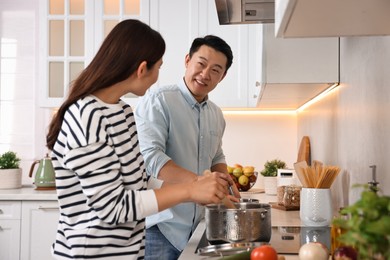 Happy lovely couple cooking together in kitchen