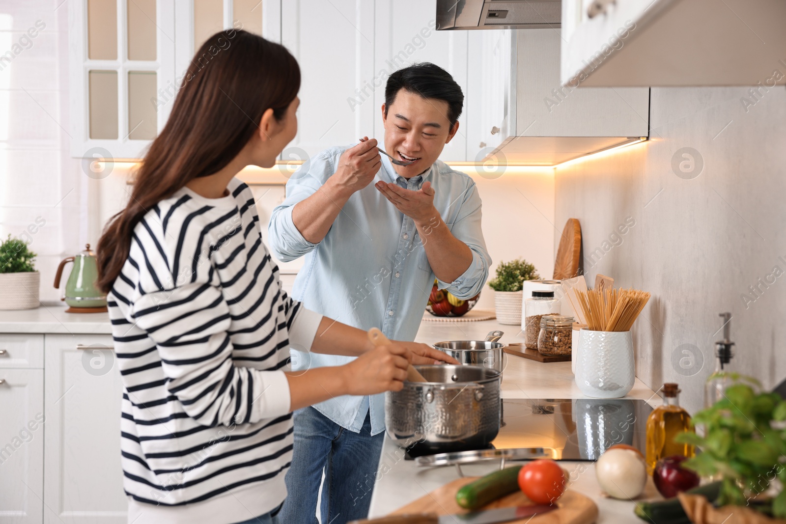 Photo of Happy lovely couple cooking together in kitchen