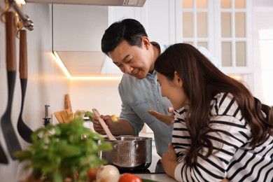 Photo of Happy lovely couple cooking together in kitchen