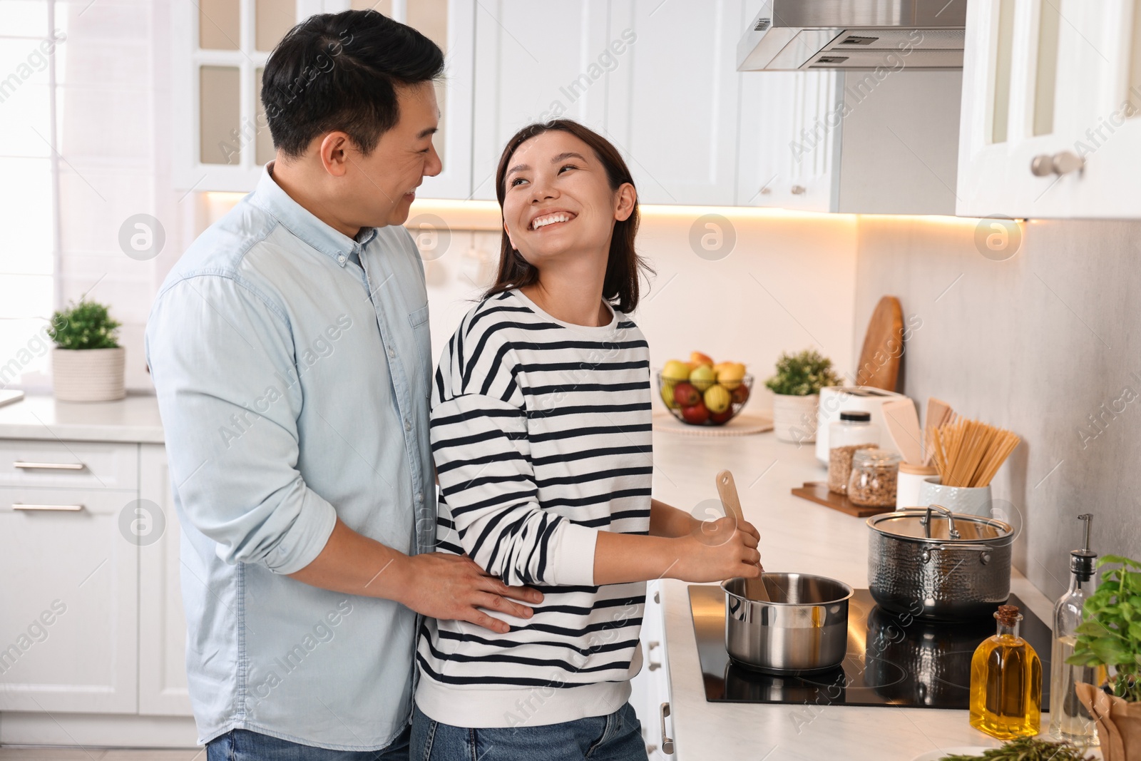 Photo of Happy lovely couple cooking together in kitchen