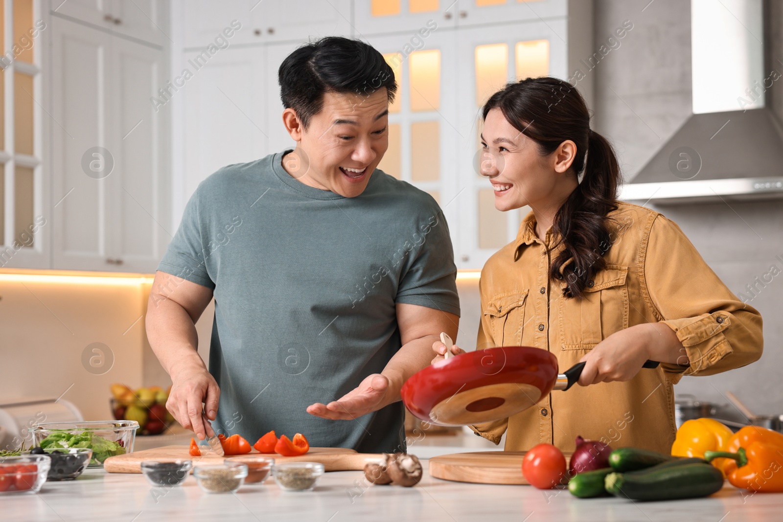 Photo of Happy lovely couple cooking together in kitchen