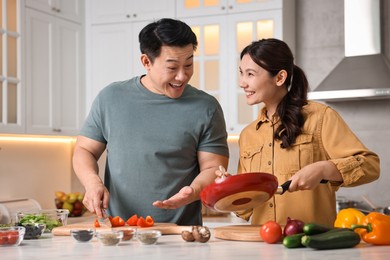 Photo of Happy lovely couple cooking together in kitchen