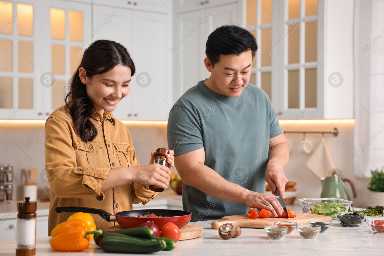 Photo of Happy lovely couple cooking together in kitchen