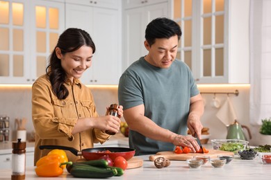 Happy lovely couple cooking together in kitchen