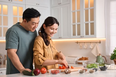 Photo of Happy lovely couple cooking together in kitchen