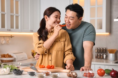 Happy lovely couple cooking together in kitchen