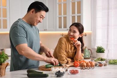 Photo of Happy lovely couple cooking together in kitchen