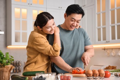 Photo of Happy lovely couple cooking together in kitchen