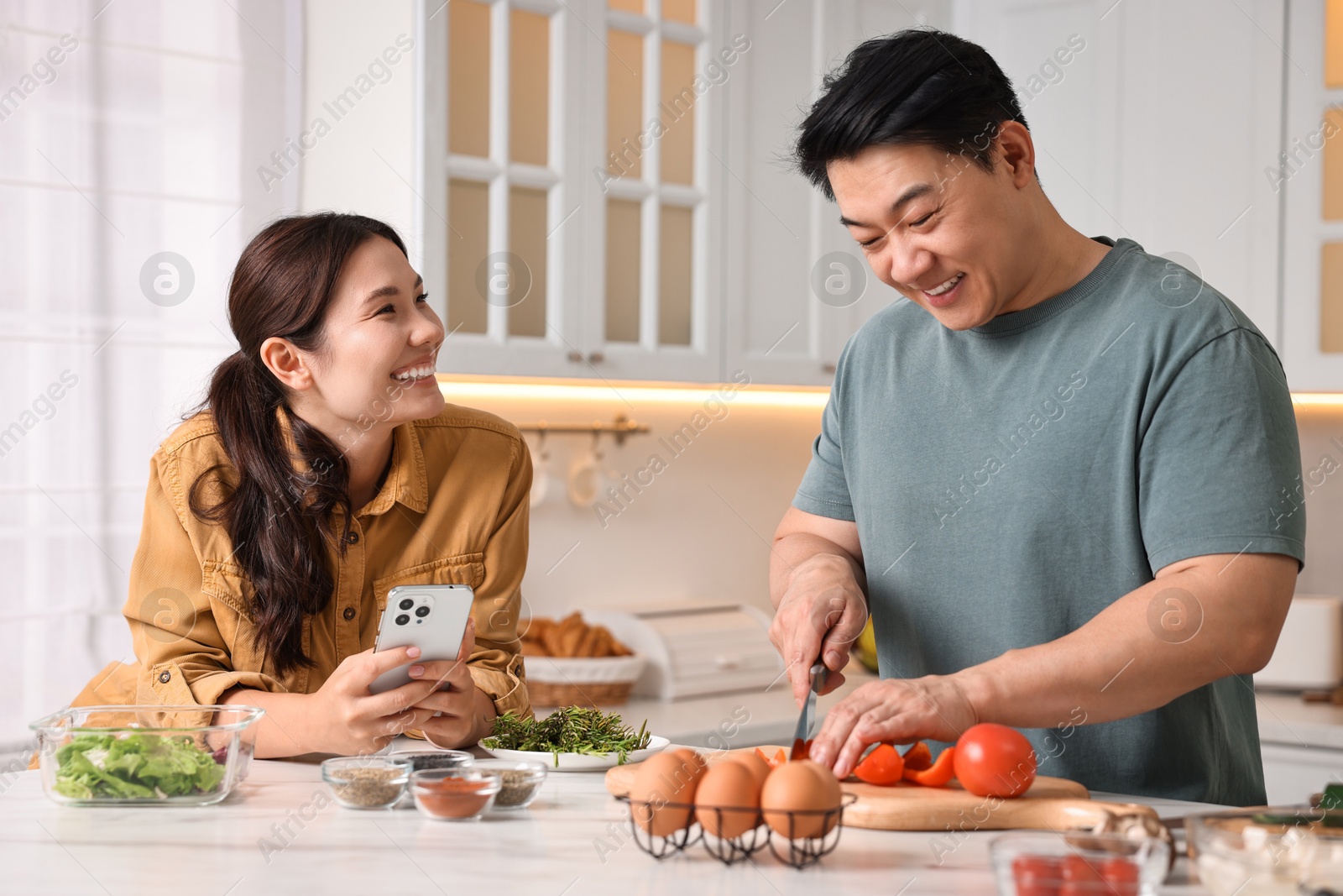 Photo of Happy lovely couple cooking together in kitchen