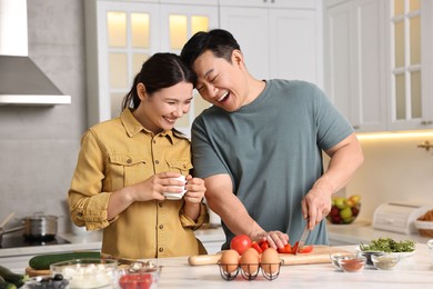 Photo of Happy lovely couple cooking together in kitchen