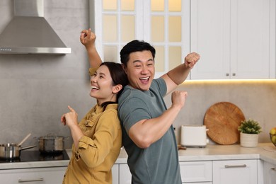 Happy lovely couple dancing together in kitchen