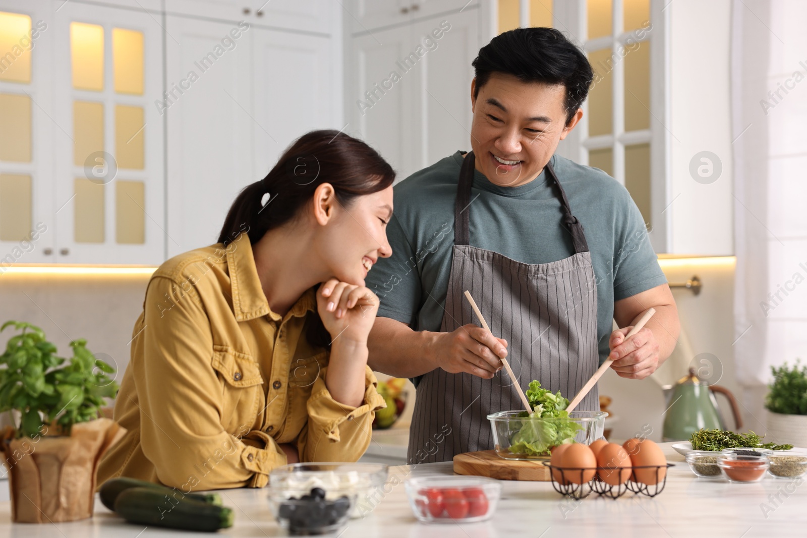 Photo of Happy lovely couple cooking together in kitchen