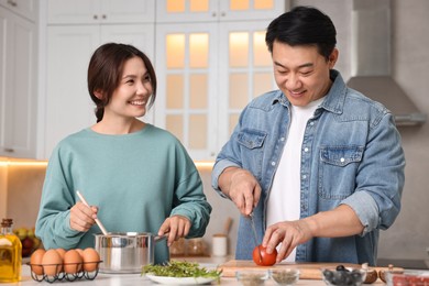 Photo of Happy lovely couple cooking together in kitchen