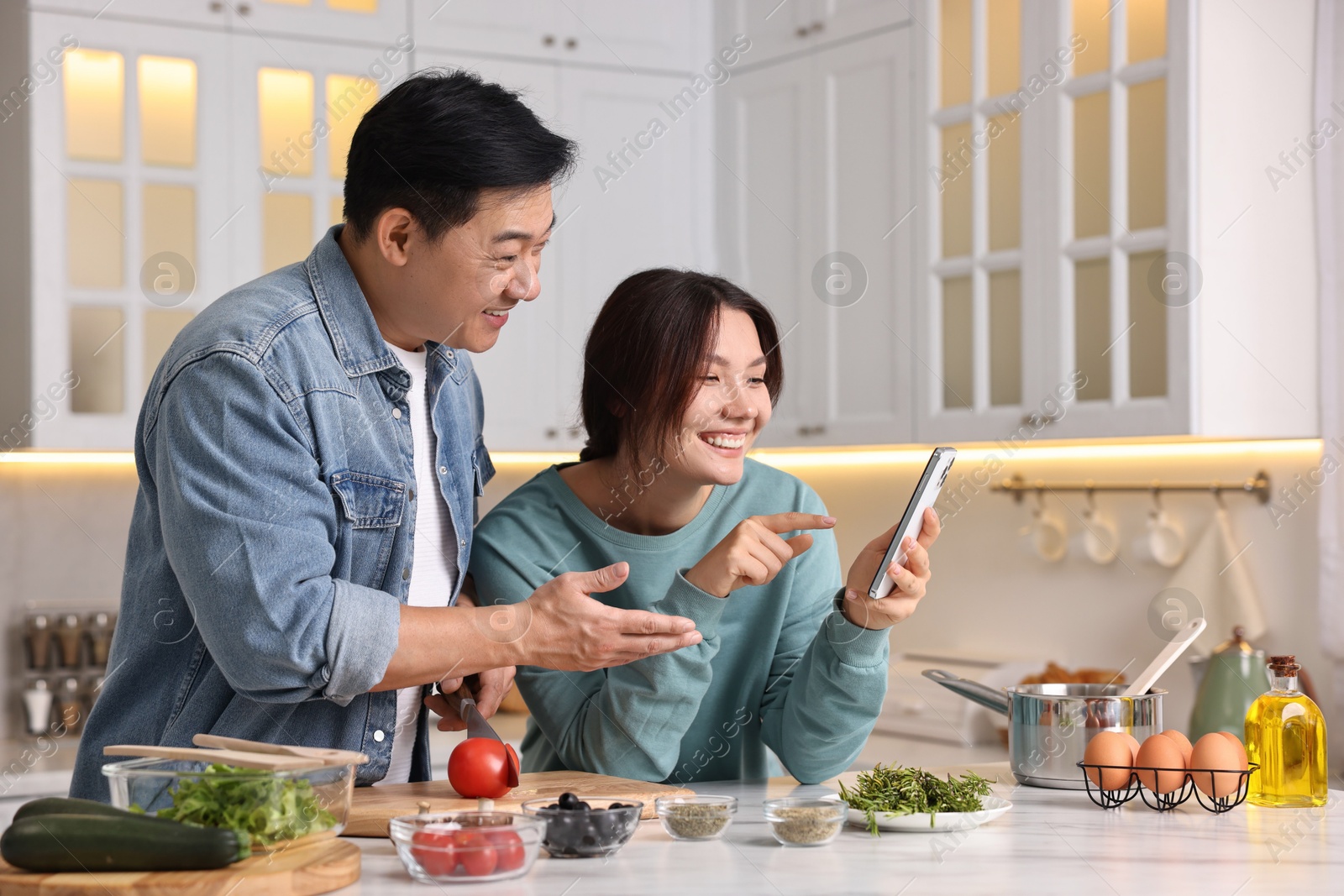 Photo of Happy lovely couple cooking together in kitchen