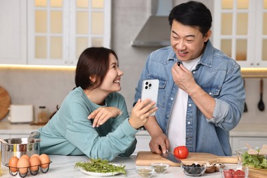 Photo of Happy lovely couple cooking together in kitchen