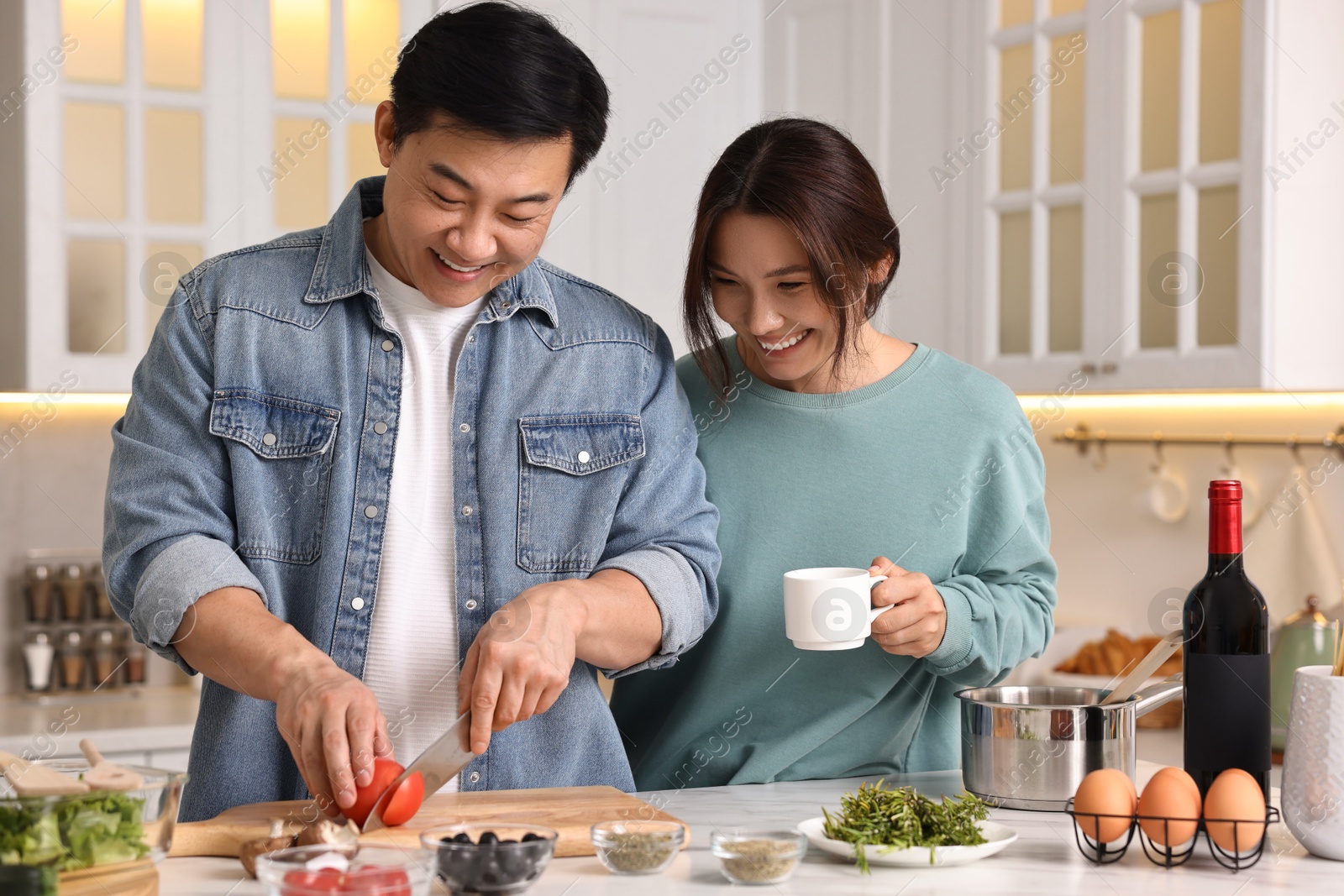 Photo of Happy lovely couple cooking together in kitchen