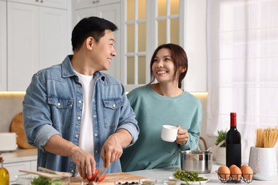 Happy lovely couple cooking together in kitchen