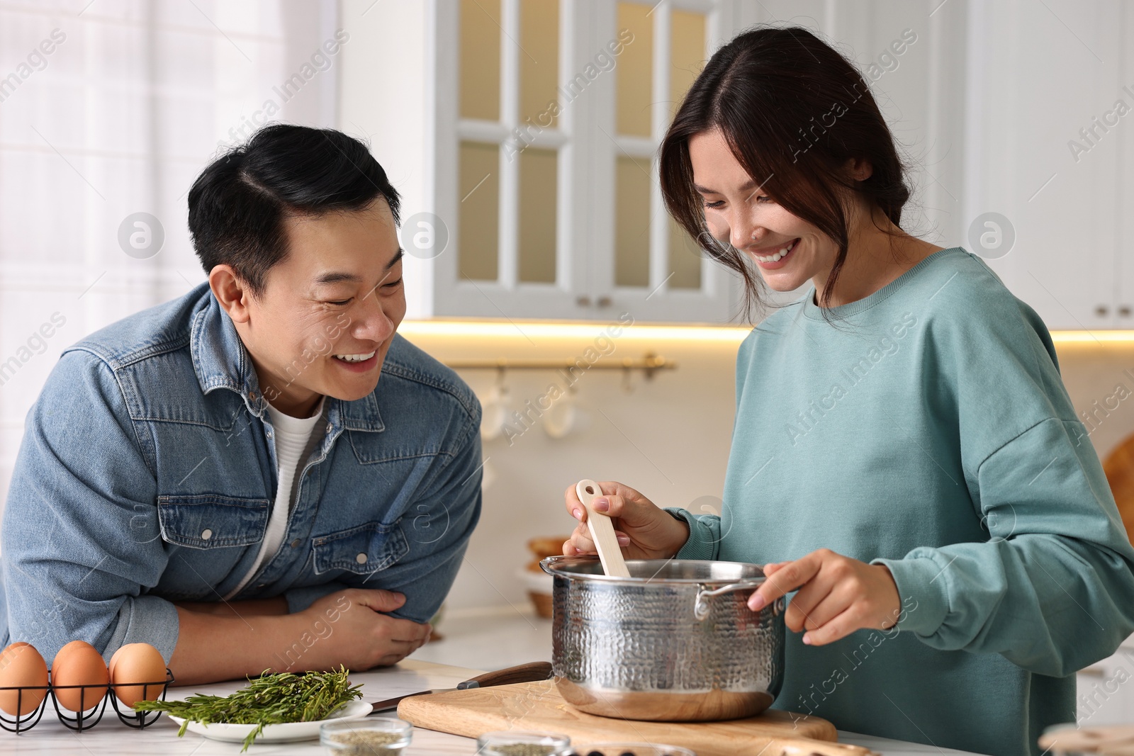 Photo of Happy lovely couple cooking together in kitchen