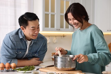 Photo of Happy lovely couple cooking together in kitchen