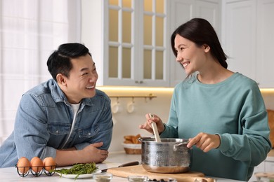 Happy lovely couple cooking together in kitchen