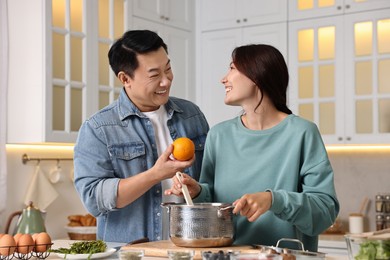 Photo of Happy lovely couple cooking together in kitchen