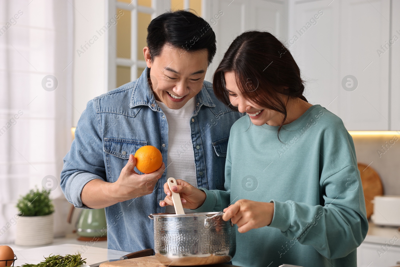 Photo of Happy lovely couple cooking together in kitchen