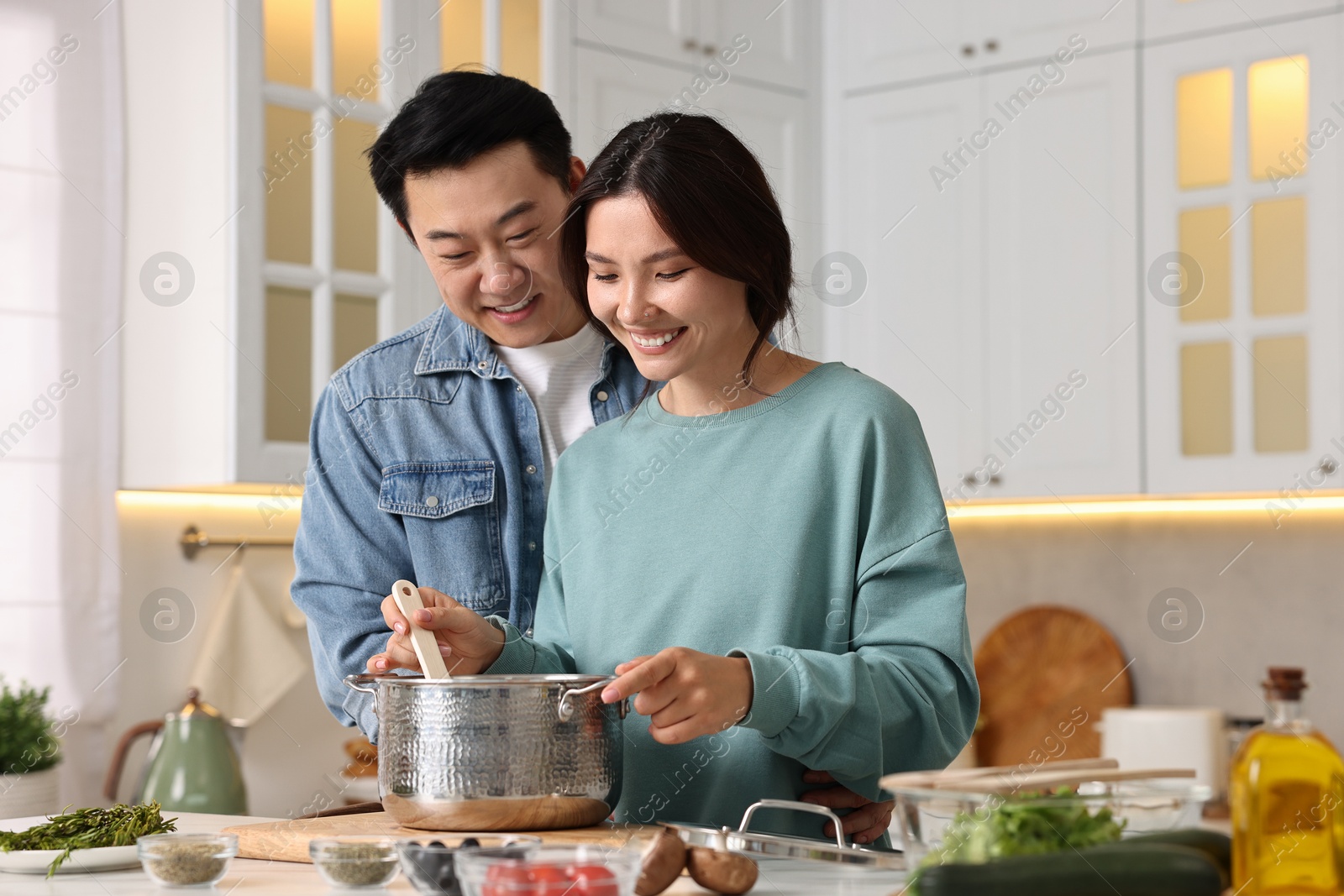 Photo of Happy lovely couple cooking together in kitchen