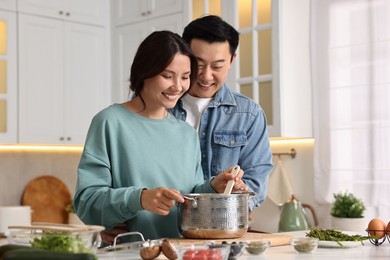 Photo of Happy lovely couple cooking together in kitchen