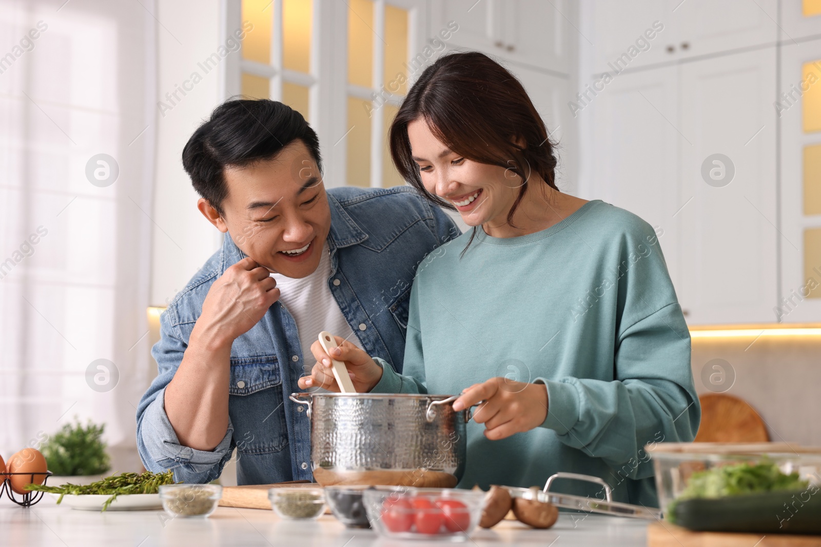 Photo of Happy lovely couple cooking together in kitchen